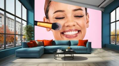 Happy woman, face and makeup brush for beauty cosmetics against a pink studio background. Female person, smile and brushing with cosmetic tool or equipment for grooming, applying or facial treatment Wall mural