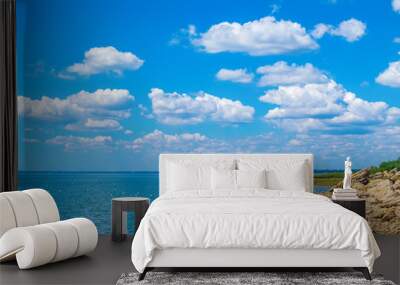 coastline of the sea with large stones, seagulls on the shore, beautiful cloudy sky on a sunny day Wall mural