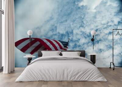 Looking up At American Flag Curled in the Wind Against Blue Sky with White Clouds Wall mural