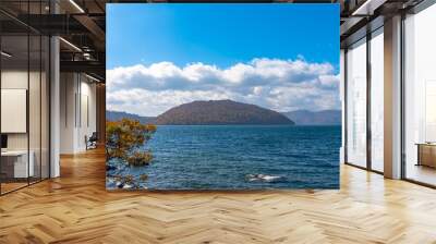 Beautiful autumn foliage scenery landscapes. Fall is full of magnificent colors. View from shore of Lake Towada, clear blue sky and water, white cloud, sunny day background. Aomori Prefecture, Japan Wall mural