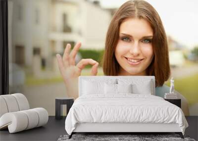 A young woman showing ok Wall mural