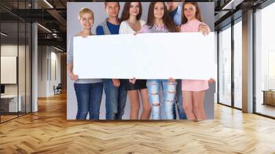 Happy young group of people standing together and holding a Wall mural