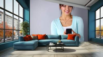 Woman using and reading a smart phone Wall mural