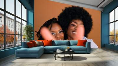 Studio portrait of two young beautiful women smiling  Wall mural