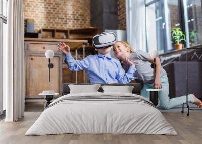 Positive little boy testing VR device with his sister Wall mural