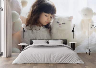 cute little girl little child sits in a bright room with a white cat Wall mural