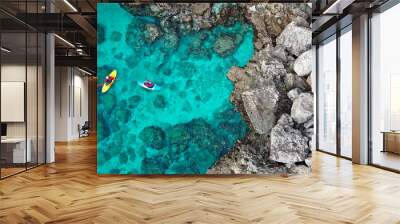 view of a drone from a drone people are kayaking in the sea near the mountains in a cave with turquoise water on the island of Cyprus Ayia Napa Wall mural