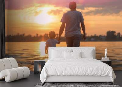 Happy father and son silhouette do muscle, child sitting on his shoulders on the grass at sunset, happy Father's Day, Father's Day concept Wall mural