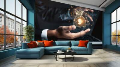 The businessman's hand uses a laptop, pointing to a virtual screen of money bag ICONS, charts or financial development charts, budgets and financial planning concepts. Wall mural