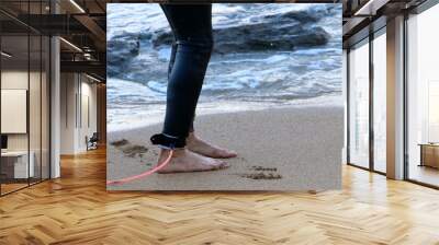 An athlete walks barefoot on the sand on the seashore. Wall mural