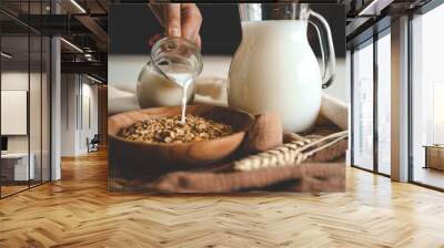 Aesthetic breakfast. Milk jug pouring milk into the bowl with natural muesli made from mix of unprocessed whole grains Wall mural