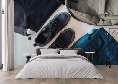 Set of men's things, flat lay top view. Sneakers, backpack, jeans and jacket on a white background Wall mural