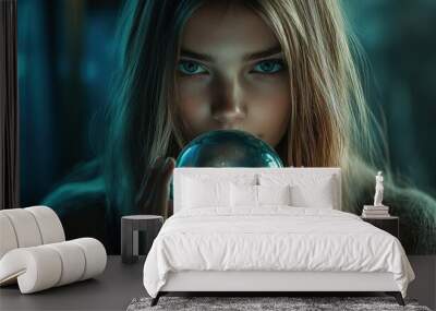 A young woman with long blonde hair gazes intently into a crystal ball, her blue eyes reflecting the light. Wall mural