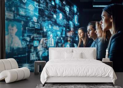 Four businesswomen looking at a large screen with digital data and icons. Wall mural