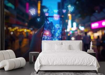 Person holding a smartphone with shopping cart icons against a city background at night. Wall mural