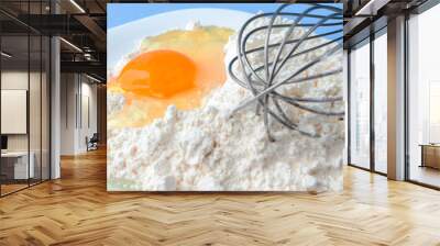 Eggs, flour, milk, sugar, and various ingredients for making pastry homemade pastry on a blue background with copy space Wall mural