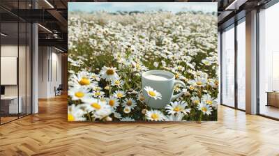 Cup of coffee in the meadow with daisies. Wall mural