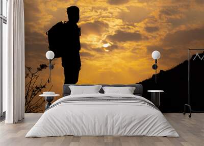 Silhouette shot of an Indian hiker staring at the sun during the sunset. Man looks at the beautiful sunset from above the hill. Natural background Wall mural