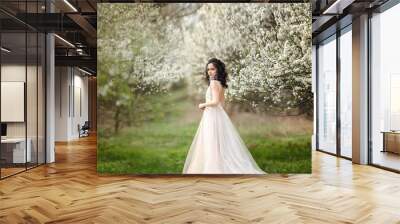 beautiful bride in a wedding dress on a background of blooming gardens, spring, wedding photo session. Wall mural