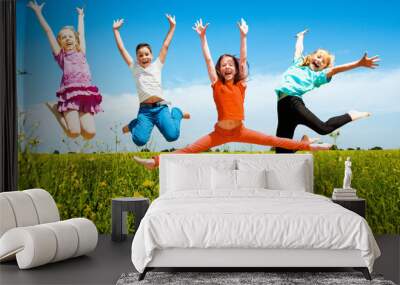 Happy active children jumping outdoors Wall mural