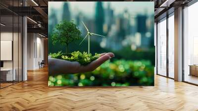 A hand holding a tree and a wind turbine. Wall mural