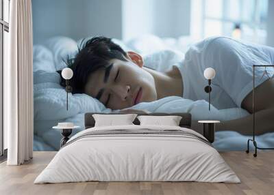 Asian man 20 yo in a white clothes laying down on white bed with white blanket, happily sleeping Wall mural