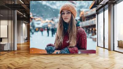 Attractive young woman posing with snowboard against the background of alpine village Wall mural