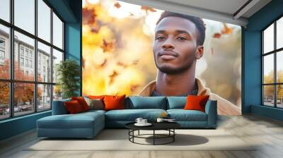 Handsome african man model portrait in the fall season autumn landscape sunny day, colorful maple leafs falling on background Wall mural