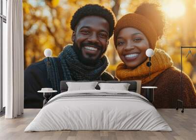 Handsome lovely african woman and man couple in the fall season autumn landscape sunny day, trees and leaves background, holding hot paper glass with coffee Wall mural