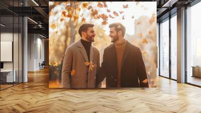 Handsome lovely gay couple in the fall season autumn landscape sunny day, maple leafs falling on them Wall mural