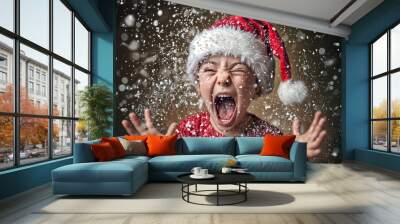 Child wearing a santa claus hat screaming and throwing snow in the air with a golden background Wall mural