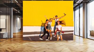 Beautiful cool young jump with confetti on a yellow background, a group of young people celebrating and having fun, summer mood, friends walking in the city in place, lifestyle Wall mural