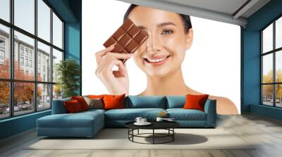 beautiful woman with dark hair, bare shoulders and neck, holding a bar of chocolate to enjoy the taste and diet Wall mural