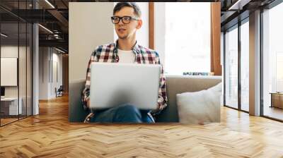 Young man working on computer, using laptop, studying online work from home, man typing on laptop computer on internet Wall mural