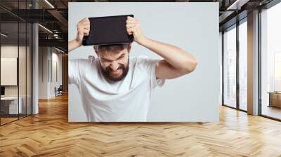 A bearded man in a white t-shirt a tablet in the hands of a professional manager communication technology Wall mural