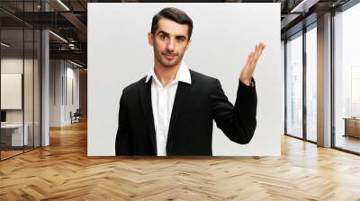 a man in a business suit holds his hand in front of him marketing manager success at work light isolated background look Copy space at the camera Wall mural