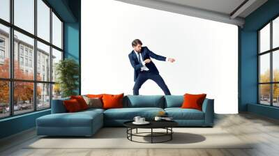 a man in a suit pulls a rope on a light background in full growth Wall mural