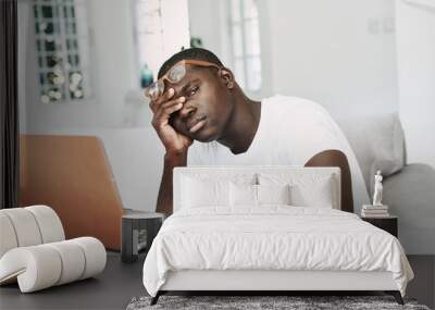 A man of African appearance at home in front of a laptop relaxing. Wall mural