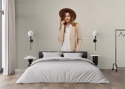 attractive woman in hat posing fashion beige background Wall mural