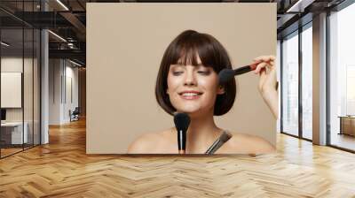 beautiful woman makeup brushes near the face bare shoulders cropped view Wall mural