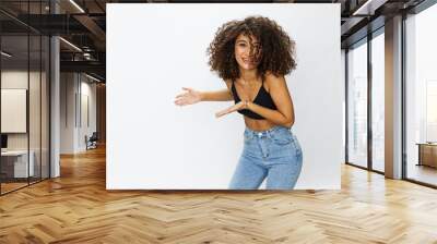 Beautiful woman with curly afro hair posing on a white isolated background smile happiness in jeans and black top emotion, hand signs, copy space Wall mural