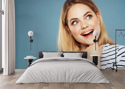 Blonde girl in striped t-shirt lifestyle blue background fun  Wall mural