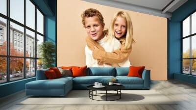 boy and girl together in sweaters fun casual wear beige background Wall mural