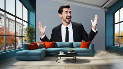 Business man happy smile with teeth open mouth raised hands up surprise on gray background in business suit. Wall mural