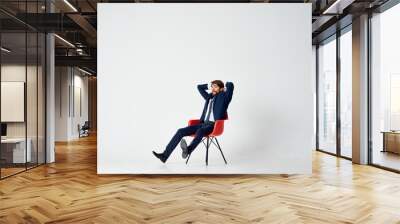 business man sitting in a red chair Wall mural