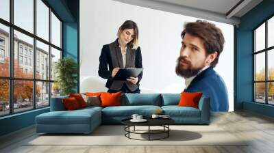 Business woman In a bright room and an upset man with a beard in the foreground is job interview Wall mural