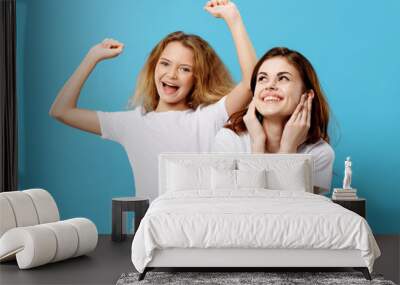 Cheerful Mom and daughter in white t-shirts joy fun family Wall mural