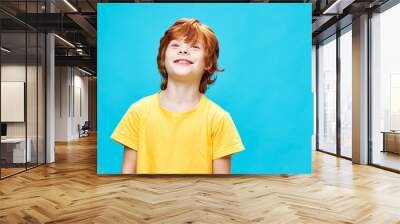 Cheerful redhead boy with head raised back yellow t-shirt smile cropped view  Wall mural