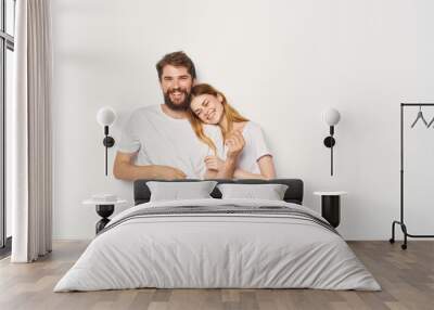 Couple in love man and woman light background fun emotions the same clothes Wall mural