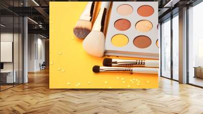 different color shades and makeup brushes on yellow background Wall mural